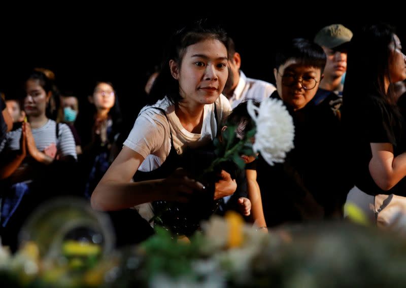 Local people place flowers as they pray for victims who died in mass shooting, involving a Thai soldier on a shooting rampage, in Nakhon Ratchasima