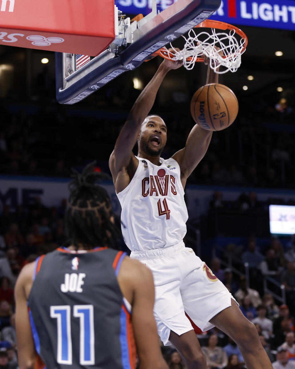 Cleveland Cavaliers forward Evan Mobley dunks in front of Oklahoma City Thunder guard Isaiah Joe during the first half of an NBA basketball game Friday, Jan. 27, 2023, in Oklahoma City. (AP Photo/Nate Billings)