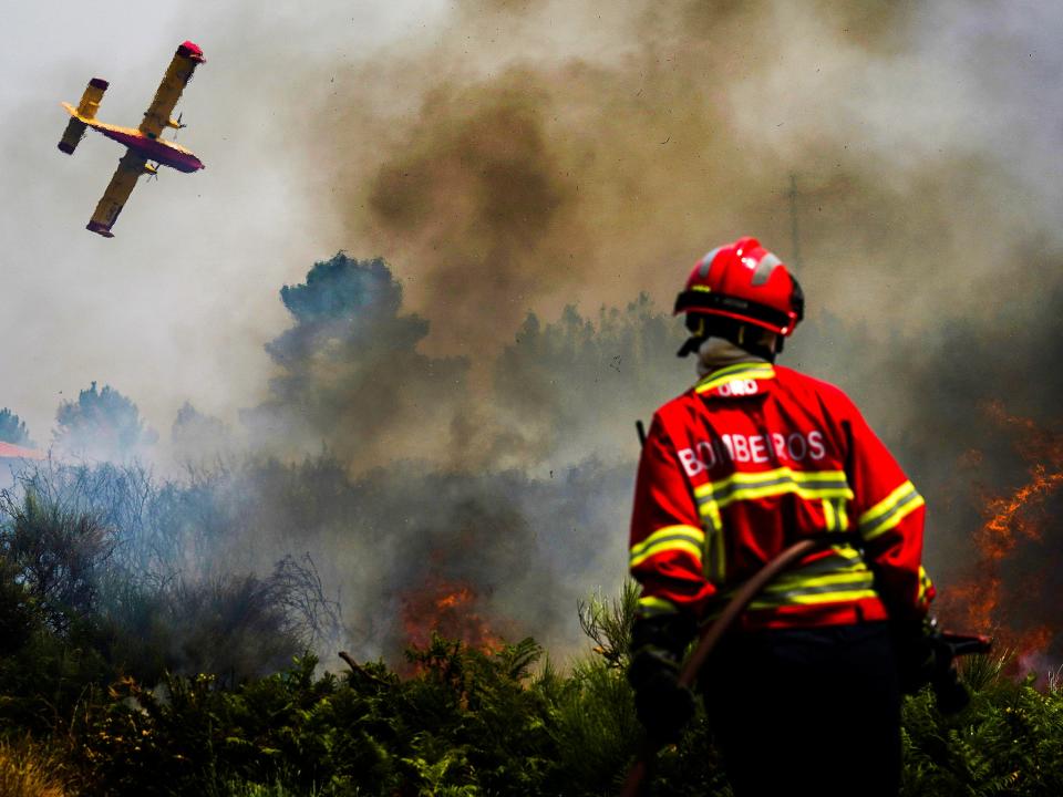 A firefighter fights the flames surrounding Ancede village during a wildfire in the municipality of Baiao (EPA/Hugo Delgado)