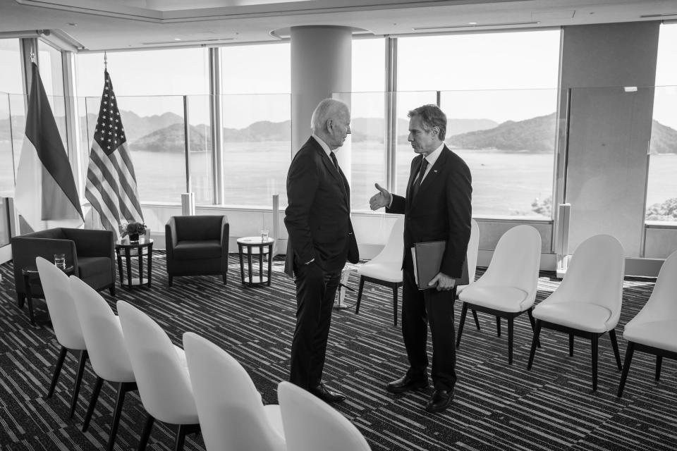 A black and white photo of Antony Blinken speaking with President Biden.