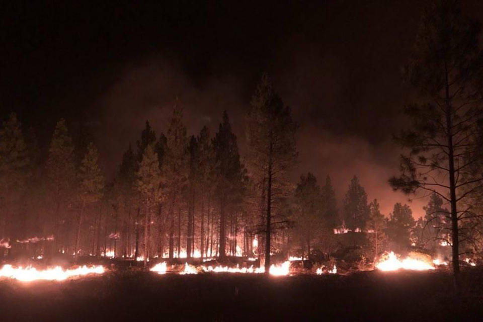 In this photo provided by the Bootleg Fire Incident Command, the Bootleg Fire burns at night near Highway 34 in southern Oregon on Thursday, July 15, 2021. Firefighters scrambled Friday to control a raging inferno in southeastern Oregon that's spreading miles a day in windy conditions, one of numerous wildfires across the U.S. West that are straining resources. The Bootleg Fire, the largest wildfire burning in the U.S., has torched more than 377 square miles (976 square kilometers), and crews had little control of it. (Jason Pettigrew/Bootleg Fire Incident Command via AP)