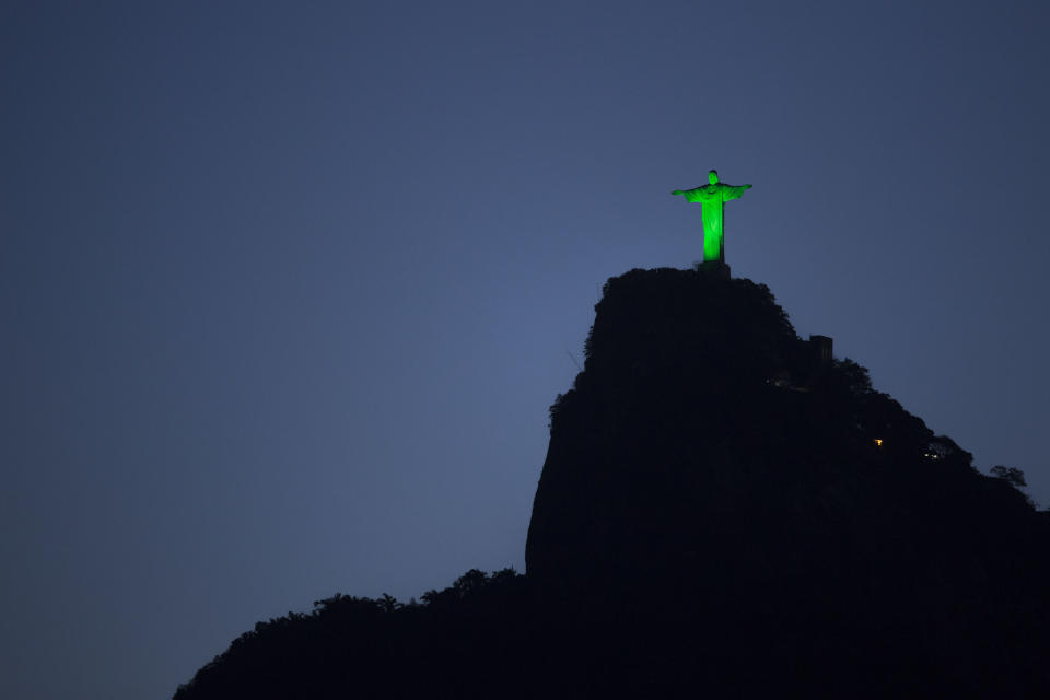 The Christ the Redeemer statue is illuminated in green in commemoration of St. Patrick's Day in Rio de Janeiro, Brazil, Monday, March 17, 2014. (AP Photo/Felipe Dana)