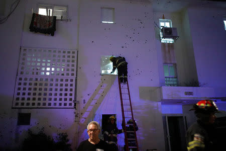 Israeli firefighters survey the scene where a rocket exploded in the southern city of Sderot, Israel August 8, 2018. REUTERS/Amir Cohen