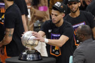 Phoenix Suns guard Devin Booker rubs the Western Conference trophy after they won Game 6 of the NBA basketball Western Conference Finals against the Los Angeles Clippers Wednesday, June 30, 2021, in Los Angeles. The Suns won the game 130-103 to take the series 4-2. (AP Photo/Mark J. Terrill)