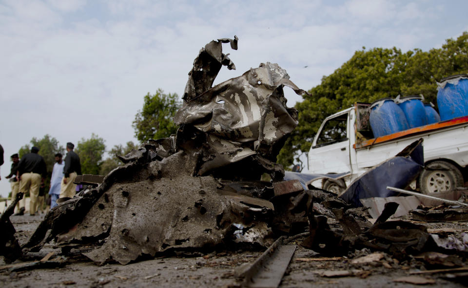 Pakistani police officer gather at the site of a bombing in Karachi, Pakistan, Thursday, Feb. 13, 2014. A bomb attack killed at least several police officers and wounded dozens others in Pakistan's southern city of Karachi on Thursday. A van exploded after hitting a bus the officers boarded moments after it had left a training school in what appeared to be a suicide attack, said police officer Rao Anwaar. (AP Photo/Shakil Adil)