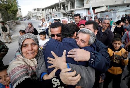 Relatives hug one of the hostages held by Islamic State militants who escaped from his captors in Qaryatayn town in Homs province, Syria October 29, 2017. REUTERS/Omar Sanadiki