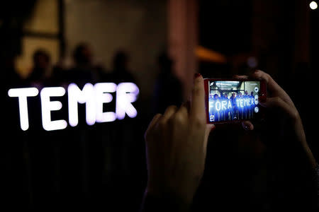 A demonstrator take a picture of banners with led lights reading "Out Temer" during a protest against Brazil's President Michel Temer in Sao Paulo, Brazil, May 18, 2017. REUTERS/Nacho Doce