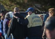 A man puts his arm on a family member who was escorted out of Arapahoe High School, following a shooting incident where a student opened fire in the school in Centennial, Colorado December 13, 2013. The student seeking to confront one of his teachers opened fire at the Colorado high school on Friday, wounding at least two classmates before apparently taking his own life, law enforcement officials said. REUTERS/Evan Semon (UNITED STATES - Tags: EDUCATION CRIME LAW)