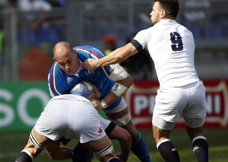 Italy's Sergio Parisse (top) is tackled by England's Chris Robshaw (down) and Danny Care during their Six Nations rugby union match at Olympic Stadium in Rome, March 15, 2014. REUTERS/Tony Gentile