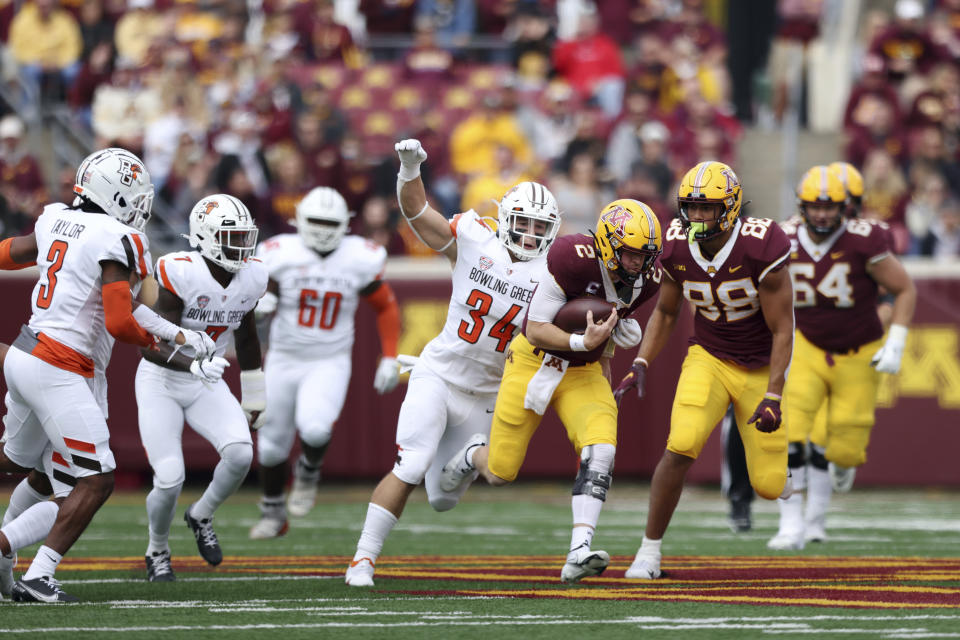 Minnesota quarterback Tanner Morgan (2) runs with the ball against Bowling Green linebacker Brock Horne (34) during the first half of an NCAA college football game Saturday, Sept. 25, 2021, in Minneapolis. (AP Photo/Stacy Bengs)