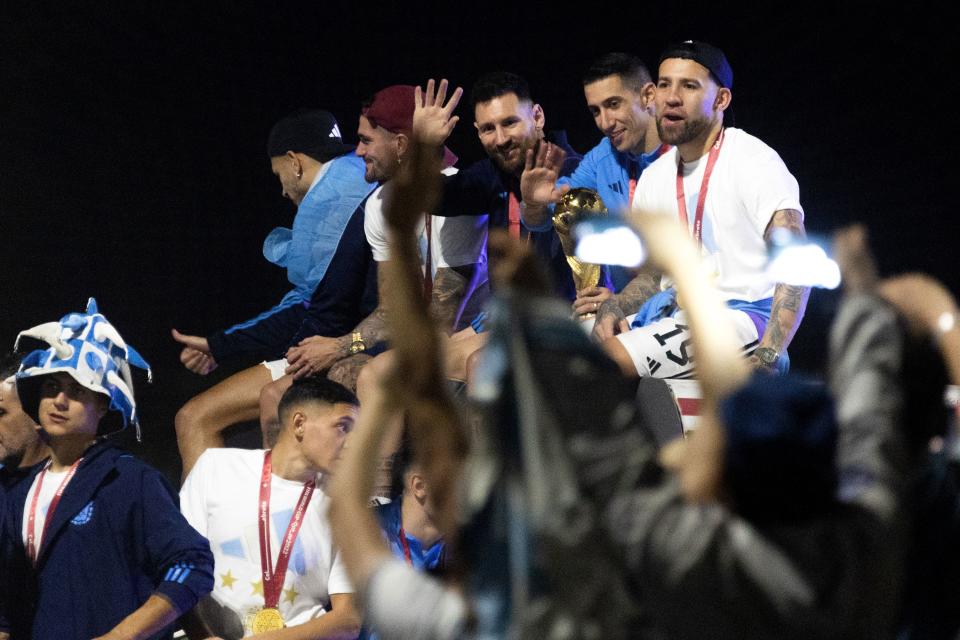 Argentina's forward Lionel Messi (C) and Argentina's midfielder Angel Di Maria (2nd R) celebrate on board a bus after winning the Qatar 2022 World Cup tournament as they leave Ezeiza International Airport en route to the Argentine Football Association (AFA) training centre in Ezeiza, Buenos Aires province, Argentina on December 20, 2022. (Photo by TOMAS CUESTA / AFP) (Photo by TOMAS CUESTA/AFP via Getty Images)