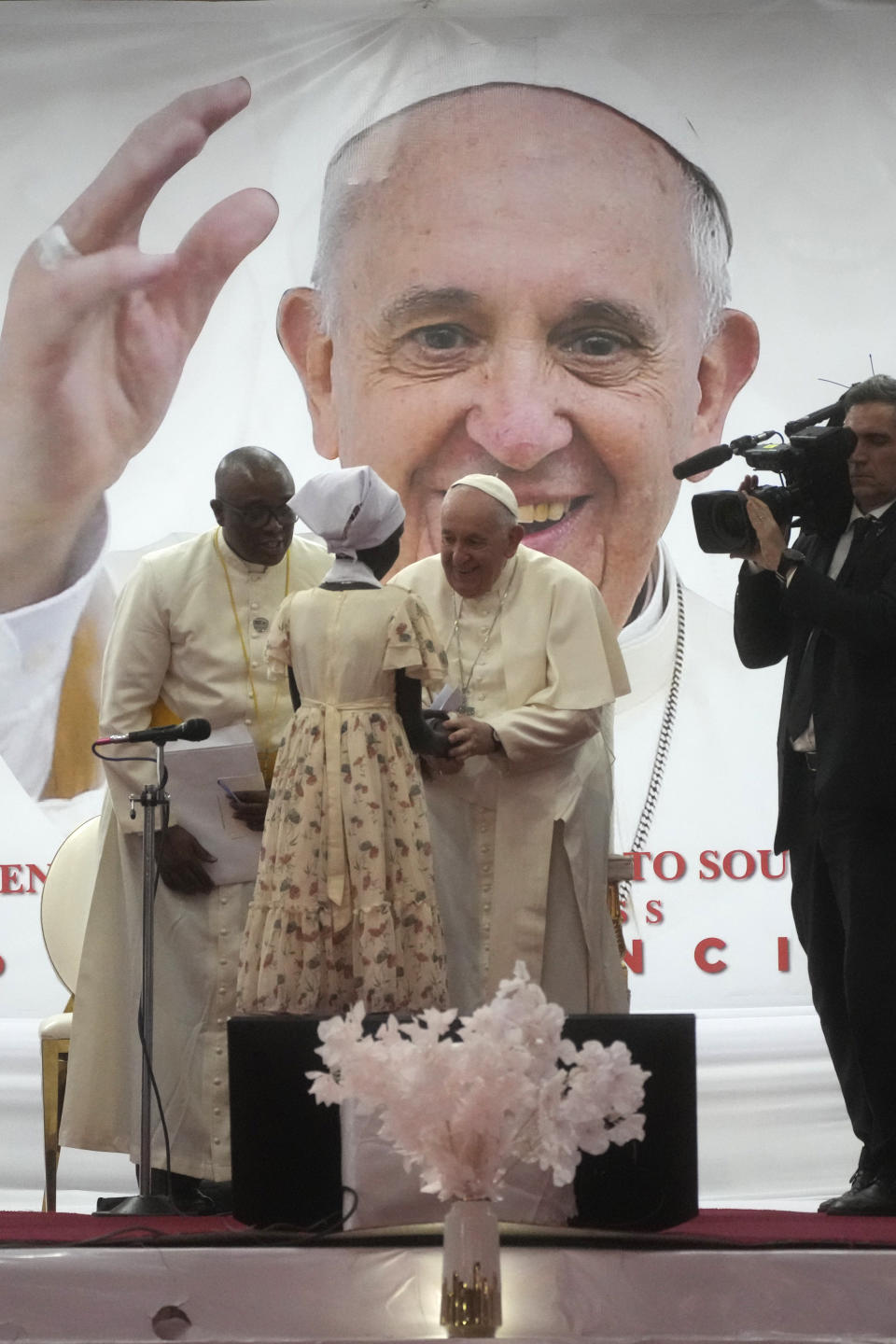 Pope Francis meets a displaced girl during a meeting with internally displaced persons in the "Freedom Hall" in Juba, South Sudan, Saturday, Feb. 4, 2023. Francis is in South Sudan on the second leg of a six-day trip that started in Congo, hoping to bring comfort and encouragement to two countries that have been riven by poverty, conflicts and what he calls a "colonialist mentality" that has exploited Africa for centuries. (AP Photo/Gregorio Borgia)