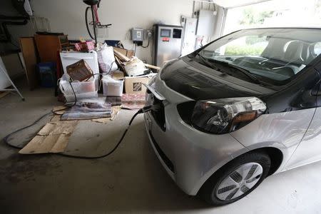 Computer science professor Christa Lopes' Scion IQ electric car is plugged in in her garage next to a residential energy storage unit in Irvine, California January 26, 2015. REUTERS/Lucy Nicholson