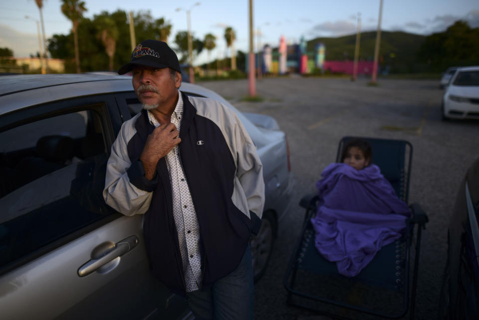 Eddie Correa, 61, and his 10-year old grand daughter Delancy Torres are up early after spending the night in their car at a parking lot after Tuesday's 6.4 magnitude earthquake in Guayanilla, Puerto Rico, at sunrise Friday, Jan. 10, 2020. Hundreds of thousands of Puerto Ricans are still without power and water, and thousands are staying in shelters and sleeping on sidewalks since Tuesday’s earthquake. (AP Photo/Carlos Giusti)