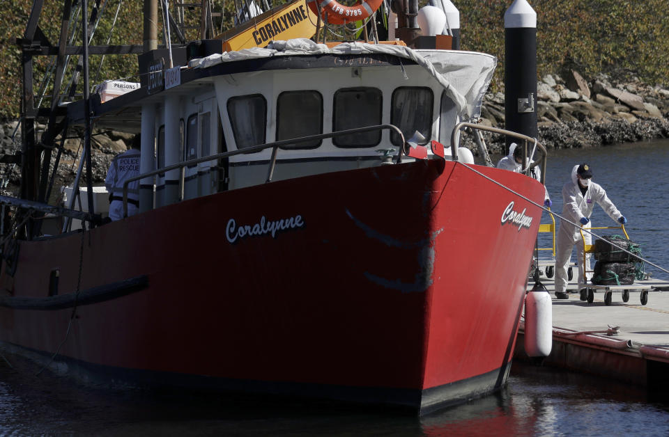 Investigators unload materials believed to be cocaine from Coralynne, an Australian trawler, in Sydney, Tuesday, Aug. 18, 2020. Australian authorities said Tuesday they seized a large quantity of cocaine from the fishing boat in treacherous seas off the east coast. (AP Photo/Rick Rycroft)