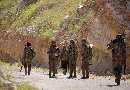 Fighters from the Syrian Democratic Forces (SDF) stand together in the village of Baghouz, Deir Al Zor province, Syria March 20, 2019. Picture taken March 20, 2019. REUTERS/Rodi Said