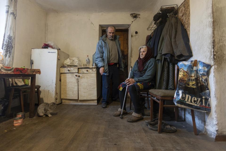 Halyna Moroka and her husband, Serhii, rest at their home in the village of Nevelske in eastern Ukraine, Friday, Dec. 10, 2021. The 7-year-old conflict between Russia-backed separatists and Ukrainian forces has all but emptied the village. “We have grown accustomed to the shelling,” said Moroka, 84, who has stayed in Nevelske with her disabled son. (AP Photo/Andriy Dubchak)