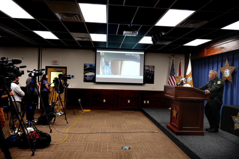 Okaloosa County Sheriff Eric Aden holds a news conference where he shared deputy body cam footage, displayed on screen at center, of the May 3, 2024 shooting of Roger Fortson, a U.S. Navy airman, Thursday, May 9, 2024, in Fort Walton Beach, Fla. Fortson was shot in his apartment after a response to a complaint. (AP Photo/Gerald Herbert)