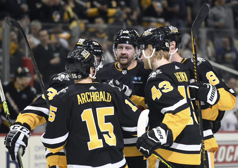 Pittsburgh Penguins right wing Josh Archibald (15) is greeted by center Nick Boninbo (13, defenseman Jeff Petry, left wing Danton Heinen (43), and defenseman Brian Dumoulin (8) after scoring against the New York Islanders during the second period of an NHL hockey game, Thursday, March 9, 2023, in Pittsburgh. (AP Photo/Philip G. Pavely)