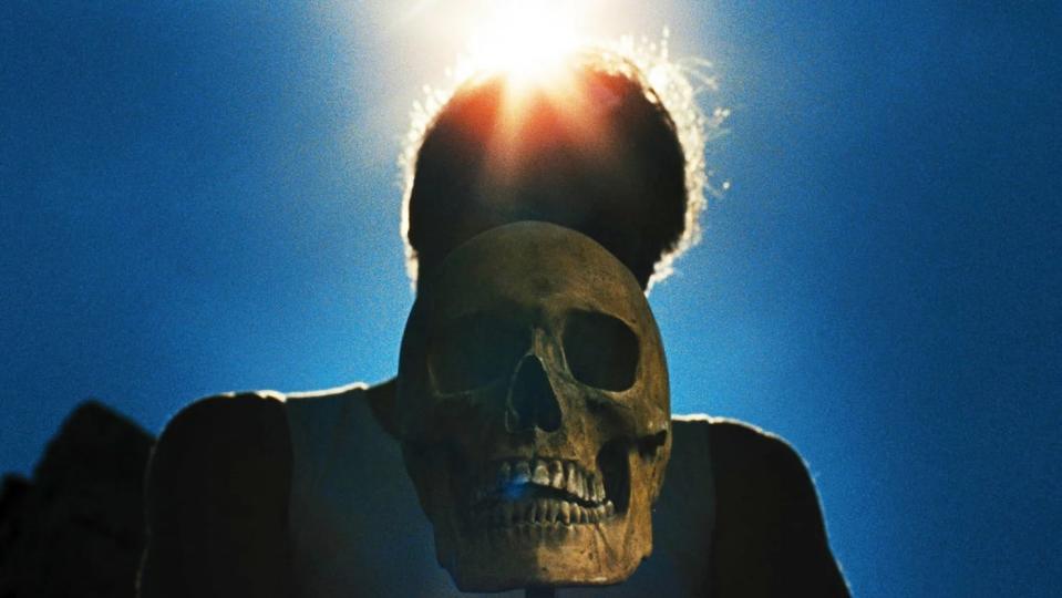 A shot of a skull in front of a silhouette bathed in sunlight in Let the Corpses Tan.