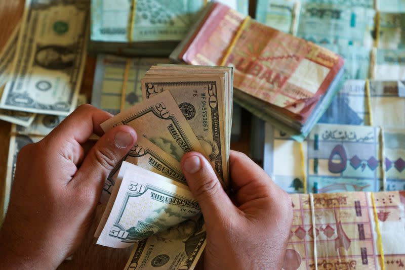 A man counts U.S. dollar banknotes at a currency exchange shop in Beirut