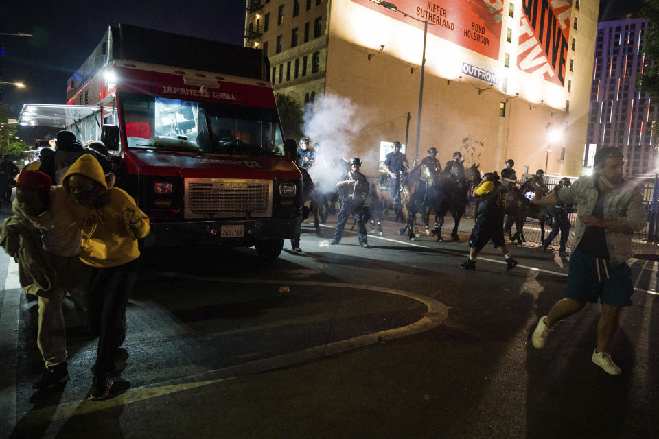 Police on horseback move people back as rowdy fans celebrate, Sunday, Oct. 11, 2020, in Los Angeles, after the Los Angeles Lakers defeated the Miami Heat in Game 6 of basketball's NBA Finals to win the championship. (AP Photo/Jintak Han)