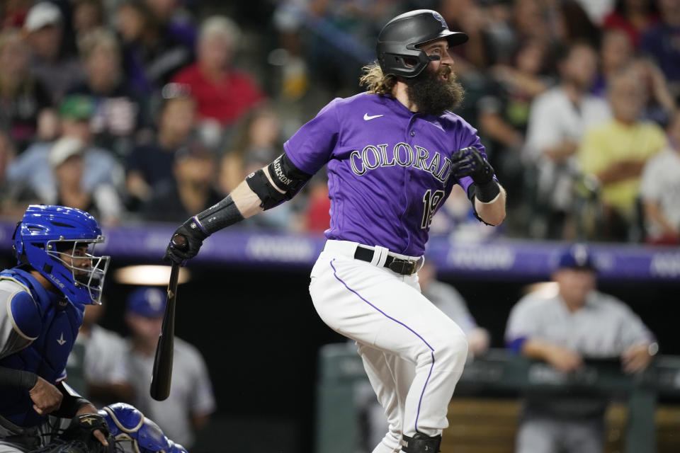 Colorado Rockies' Charlie Blackmon follows the flight of his RBI-single off Texas Rangers starting pitcher Dane Dunning in the fifth inning of a baseball game Tuesday, Aug. 23, 2022, in Denver. (AP Photo/David Zalubowski)