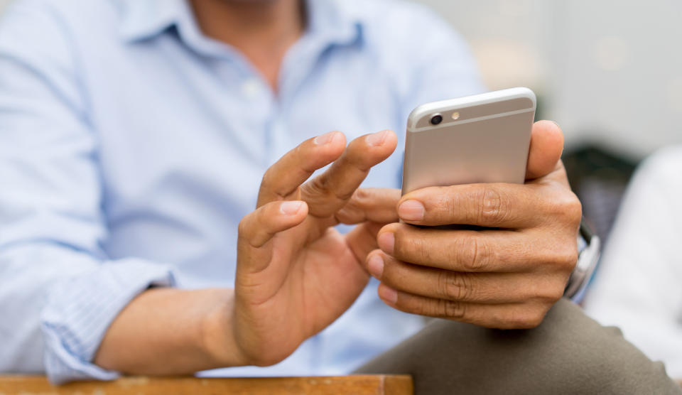 close up mature businessman holding smartphone and checking news from company by texting to employee , business and technology concept