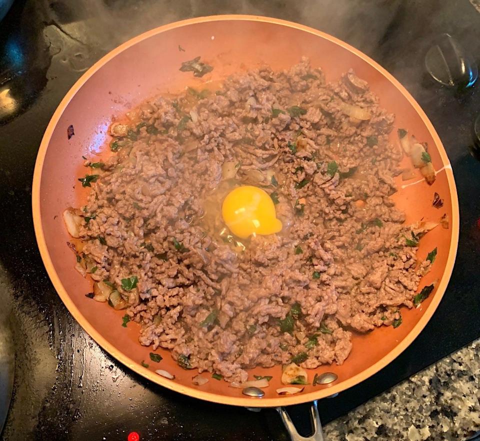 Ground beef with an egg in a pan