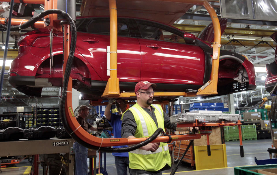 Ford Motor assembly worker Jeff Danes uses an ergonomic arm as he demonstrates how the battery charger for Ford Focus Electric vehicles will be installed when the Electric Focus goes into production at the Michigan Assembly Plant in Wayne, Michigan December 14, 2011.   REUTERS/Rebecca Cook  (UNITED STATES - Tags: TRANSPORT BUSINESS EMPLOYMENT)