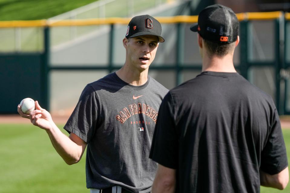 Giants' Tyler Rogers talks to his twin brother Taylor during a spring training workout.