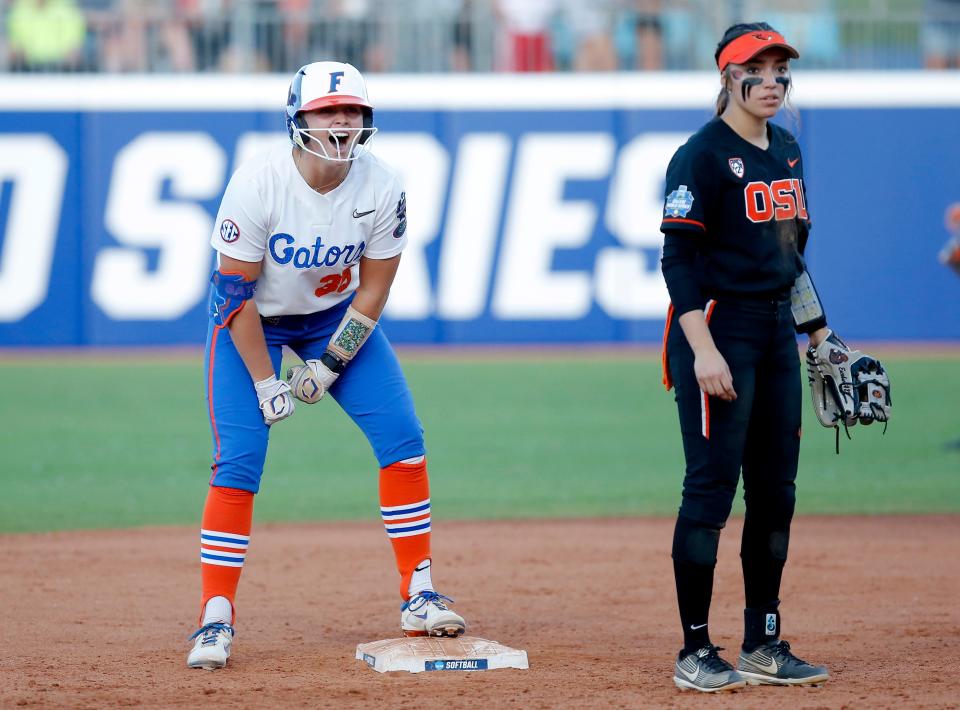 Florida's Cali Decker (35) celebrates a double next to Oregon St.'s Kiki Escobar (29) during a Women's College World Series softball game between the Oregon State Beavers and the University of Florida  at USA Softball Hall of Fame Stadium in Oklahoma City, Thursday, June, 2, 2022. 