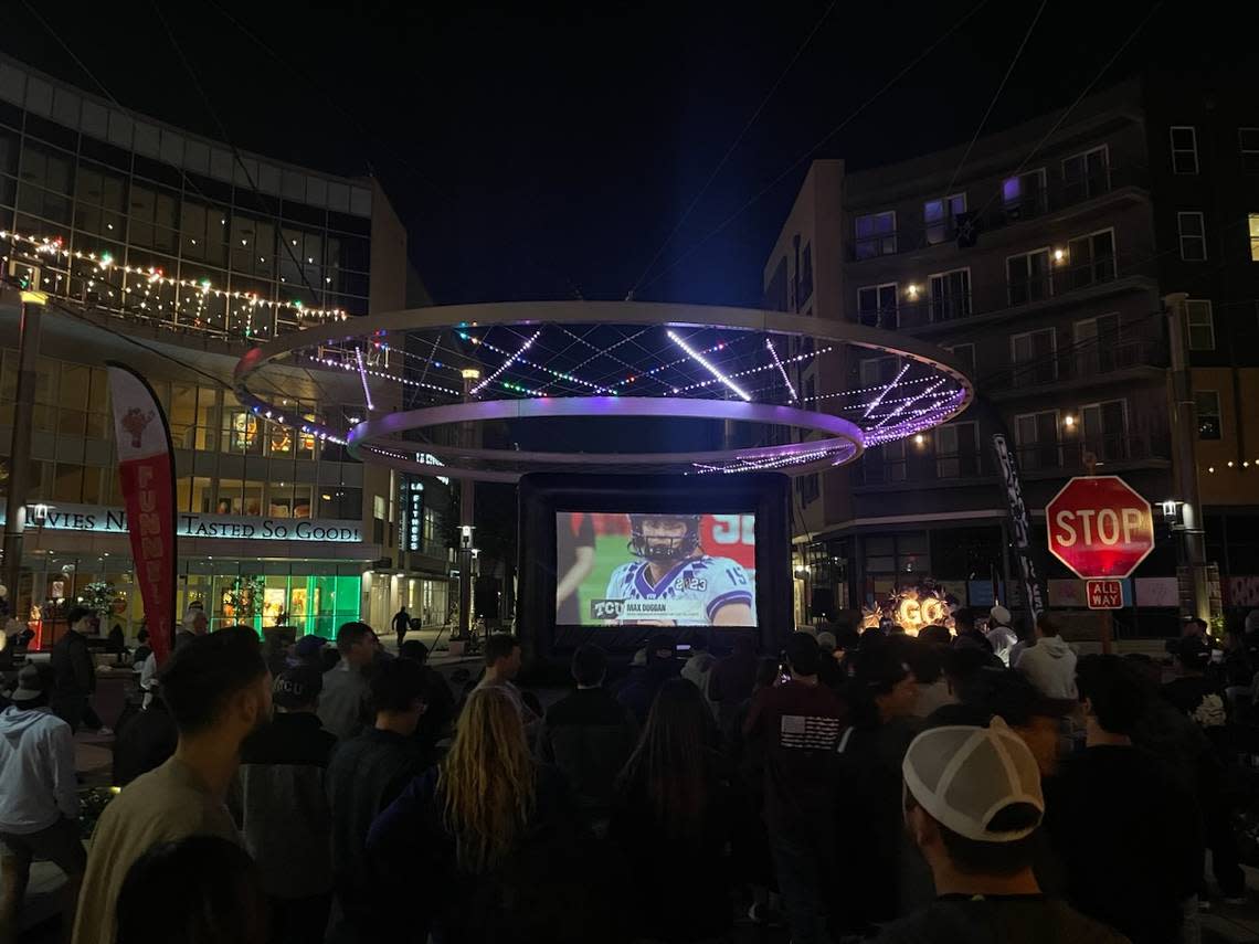 Two outdoor 25-foot TV screens near the intersection of Crockett and Currie streets on Fort Worth’s Crockett Row broadcast the game as TCU and Georgia compete in the College Football Playoff National Championship.