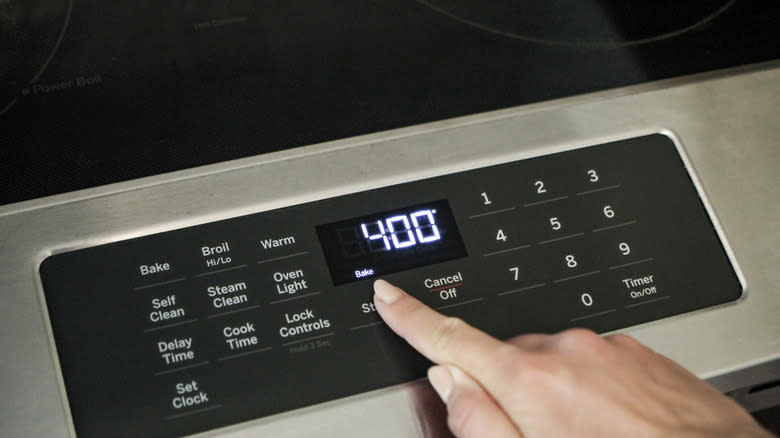 Finger turning on oven to 400.