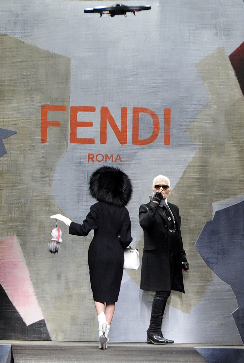 Fashion designer Karl Lagerfeld is seen at the end of Fendi women's Fall-Winter 2014-15 collection, part of the Milan Fashion Week, unveiled in Milan, Italy, Thursday, Feb.20, 2014. At the top is a drone camera flying over the catwalk. (AP Photo/Giuseppe Aresu)