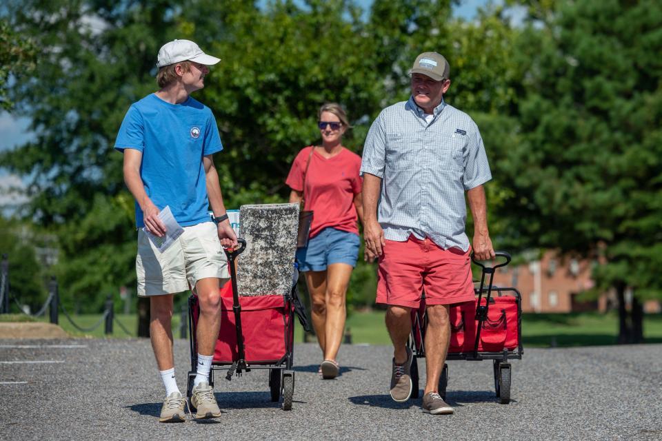 Baylor Garland, left, arrives to move in for his freshman year, assisted by his father, Alan, right and mother, Teena, after they arrived from Eaton, Ga., at the University of Alabama on Aug. 15 in Tuscaloosa.