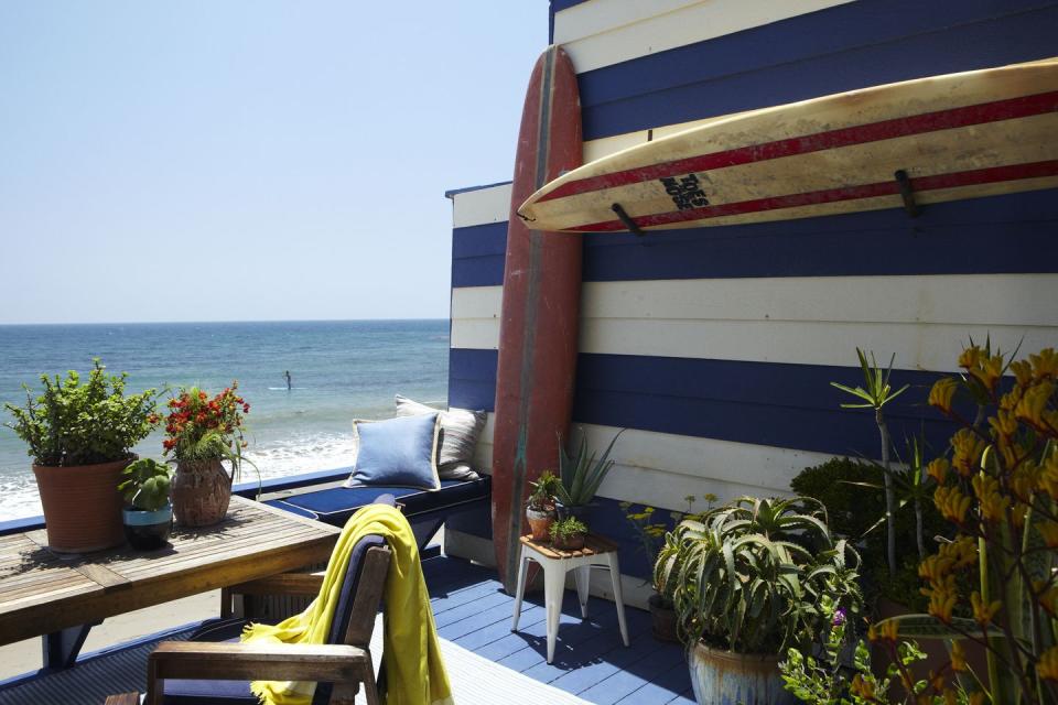 <p>A nautical-themed outdoor deck area <a href="https://www.elledecor.com/design-decorate/house-interiors/a5323/nathan-turner-and-eric-hughes-beach-apartment/" rel="nofollow noopener" target="_blank" data-ylk="slk:designed by Nathan Turner and Eric Hughes;elm:context_link;itc:0;sec:content-canvas" class="link ">designed by Nathan Turner and Eric Hughes</a> features blue-and-white-striped walls to complement the ocean views. </p>