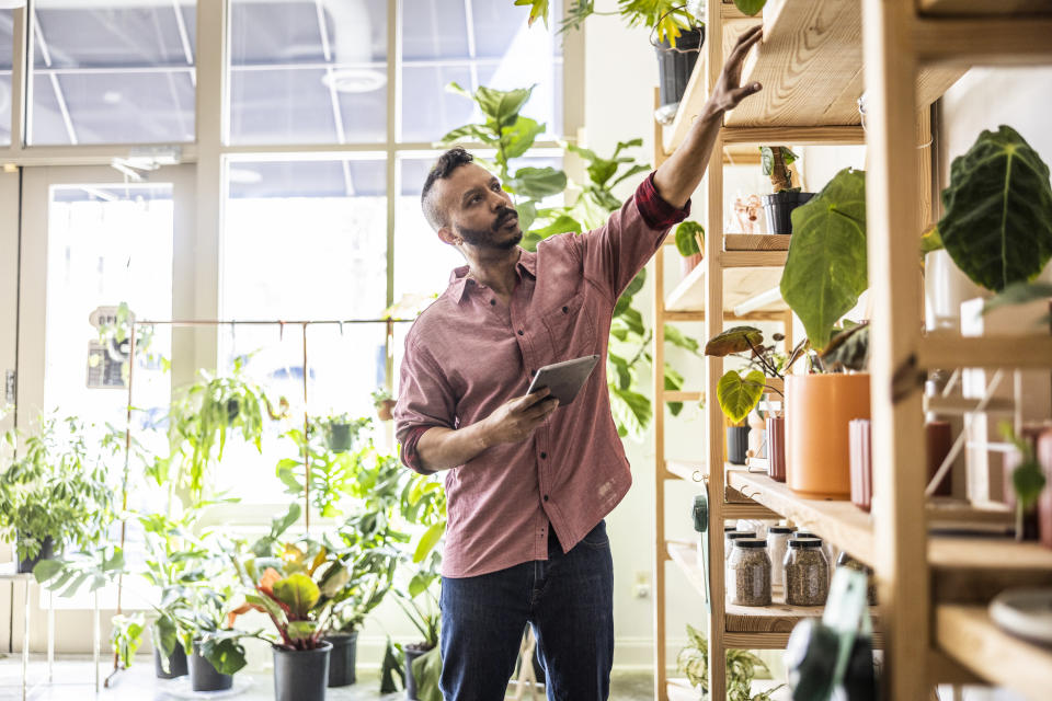 A flower shop owner checks on the business' inventory