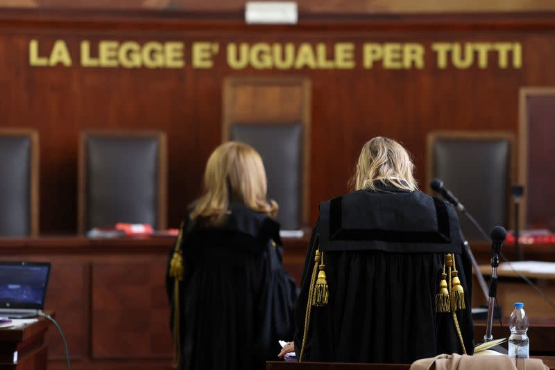 Two judges stand in a courtroom at Milan Court of Justice