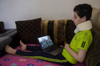 Hoda Kinno, 11, looks at an photograph on a computer that was taken by Associated Press Photographer Hassan Ammar when she was evacuated by her uncle Mustafa in the aftermath of the massive explosion at Beirut port on Aug. 4, at a temporary apartment in Jiyeh, south of Beirut, Lebanon, Tuesday, Sept. 15, 2020. (AP Photo/Hassan Ammar)