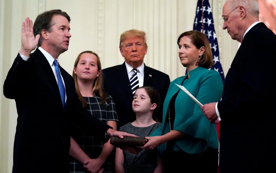 Brett Kavanaugh participates in his ceremonial public swearing-in with retired Justice Anthony Kennedy as U.S. President Donald Trump and Kavanaugh's wife Ashley and daughters Liza and Margaret look on  - REUTERS/Jonathan Ernst