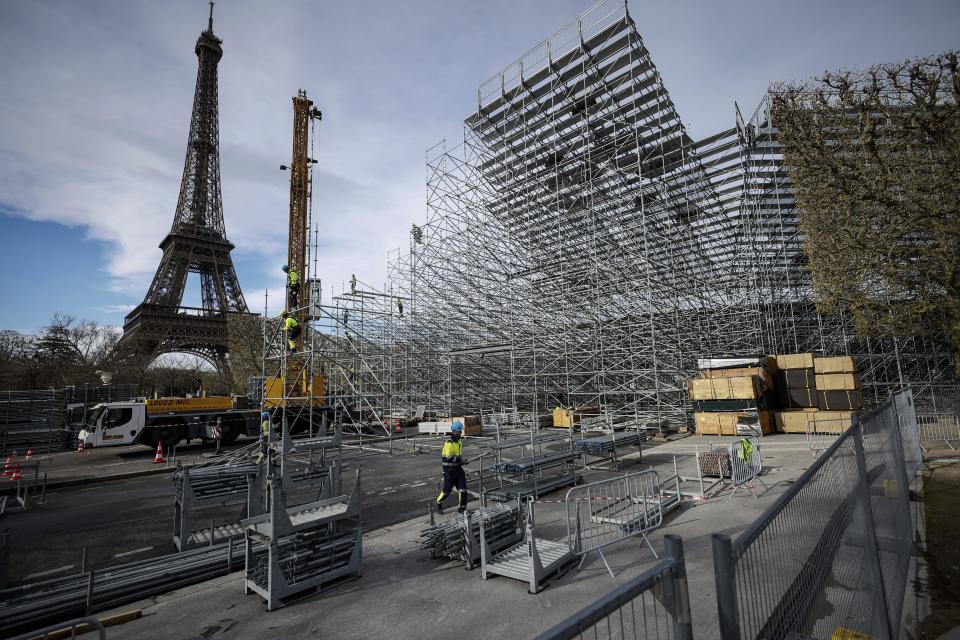 FILE - Workers build the stands for the upcoming Olympic Games on the Champ-de-Mars just beside the Eiffel Tower, in Paris, April 1, 2024 in Paris. (AP Photo/Thomas Padilla, File)