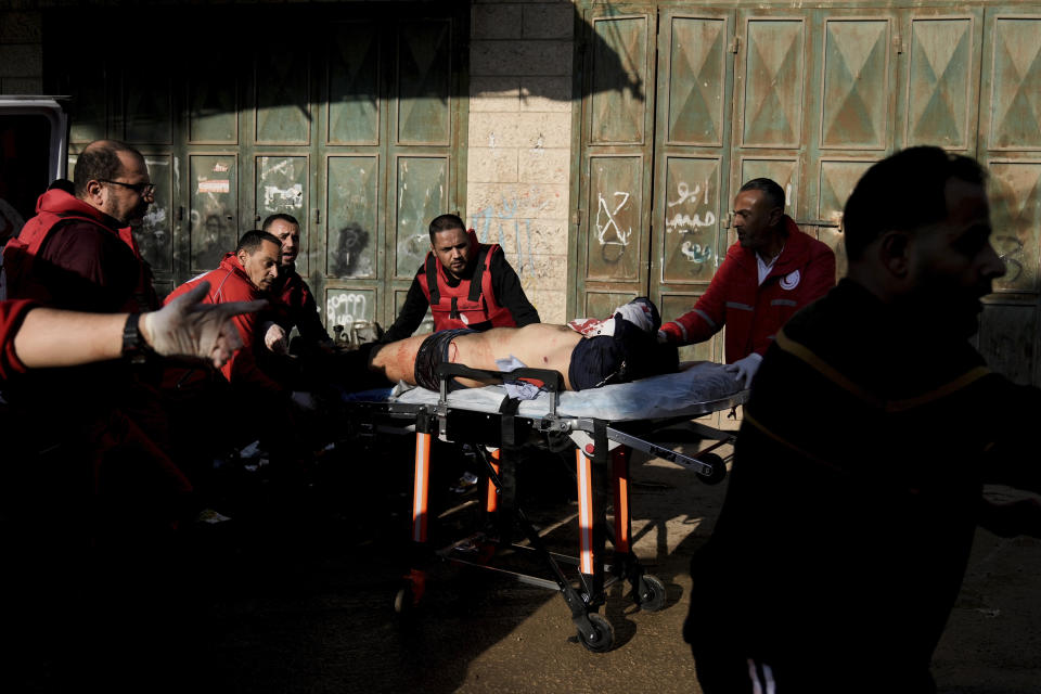 Medics evacuate a wounded Palestinian following an Israeli military raid in Faraa refugee camp, West Bank, Friday, Dec. 8, 2023. The Palestinian Health Ministry says that five Palestinians were killed when Israeli forces raided the camp prompting fighting with local militants. (AP Photo/Majdi Mohammed)