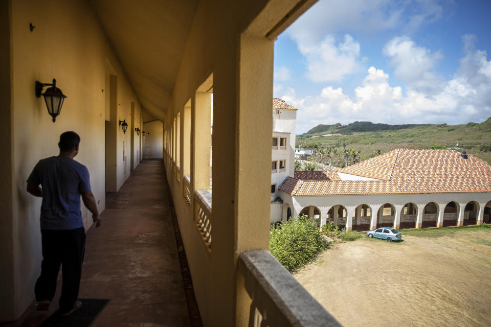 A caretaker walks through the vacant halls of the former Accion Hotel which was a seminary but is now for sale by the Catholic Church, in Yona, Guam, Wednesday, May 8, 2019. The Guam archdiocese filed for bankruptcy protection earlier this year, liquidating some of its real-estate holdings, estimating at least $45 million in liabilities. (AP Photo/David Goldman)