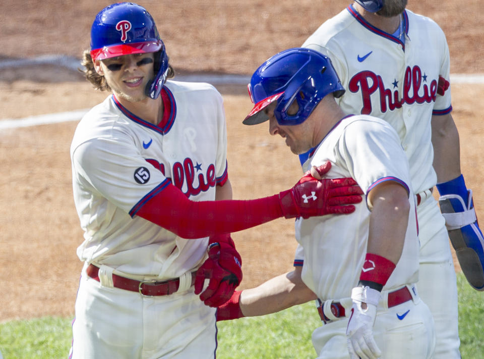 Philadelphia Phillies Alec Bohm, left, is congratulated by J.T. Realmuto after he hit a home run during the first inning of a baseball game against the New York Mets, Wednesday, April 7, 2021, in Philadelphia. (AP Photo/Laurence Kesterson)