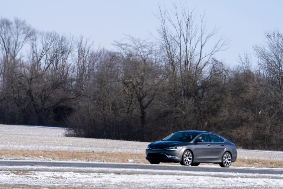 A car drives past wetlands that may soon be home to a warehouse on Sunday, Jan. 24, 2023, on the far south side of Indianapolis.