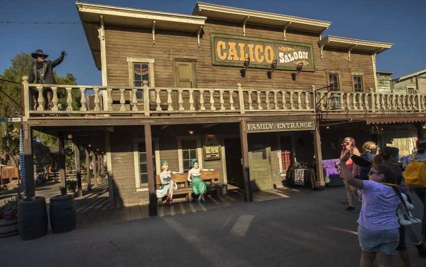 BUENA PARK, CA -JULY 31, 2020: Clay Mayfield, above left, dressed up as an outlaw, waves to visitors during Knott's Tase of Calico event at Knott's Ghost Town in Buena Park. Knott's Taste of Calico is a specially ticketed, limited-time outdoor dining and retail experience. (Mel Melcon / Los Angeles Times)