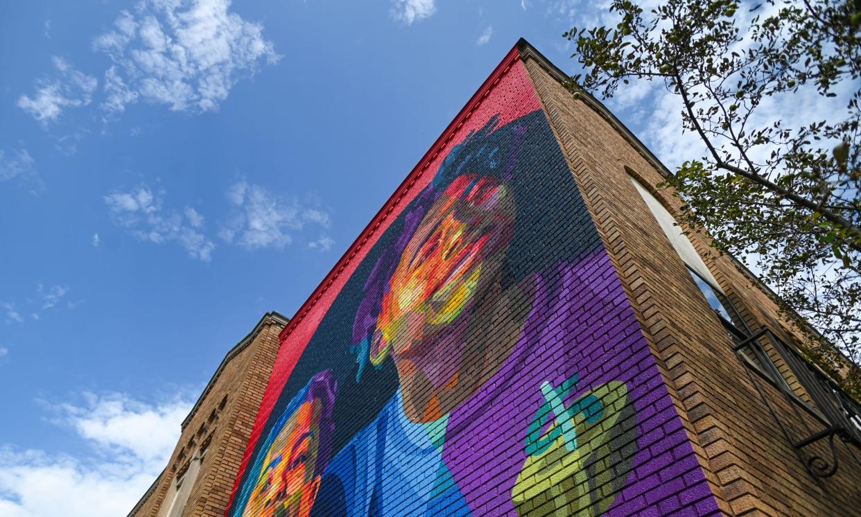 A finished section of Dustin Hunt's three-part mural project entitled "Lansing Shaped," seen Friday, Aug. 23, 2024, on the southern wall of Scribbles and Giggles in Lansing, formerly Verlinden Elementary School. Hunt's series of portraits will depict three generations of a Lansing family - children, parents, and grandparents, at three different schools.