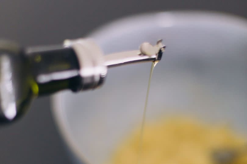 Mexico, Queretaro, Queretaro - April 6, 2020: Adding olive oil to mashed bananas in a bowl. Series of images  of the process of making vegan banana bread.