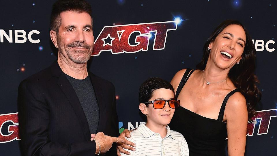 Simon Cowell posing with his son Eric and fiancée Lauren Silverman backstage at AGT